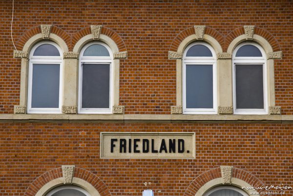 Backsteinfassade mit Fenstern und Ortsschild, Bahnhof Friedland, Friedland, Deutschland