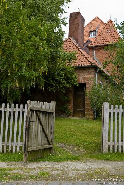 offenes Gartentor, dahinter Backsteingebäude der Stiftsmühle, Stift Bassum, Bassum, Deutschland