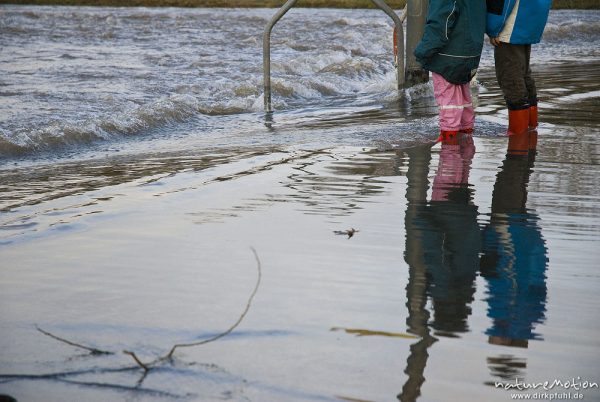 überschwemmte Straße, Kinder stehen mit Gummistiefeln im Wasser, Sandweg am Kiessee, Göttingen, Deutschland