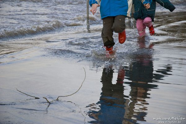 überschwemmte Straße, Kinder laufen mit Gummistiefeln im Wasser, Sandweg am Kiessee, Göttingen, Deutschland