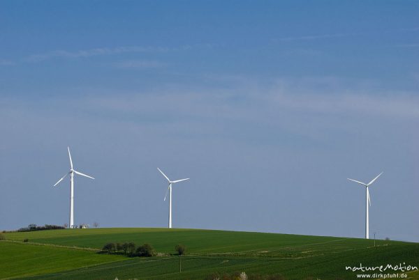 Windkraftanlagen auf Hügelkuppe vor blauem Himmel, Ebergötzen bei Göttingen, Deutschland