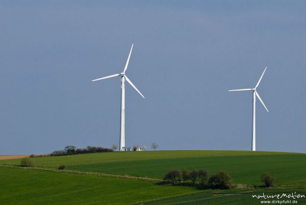 Windkraftanlagen auf Hügelkuppe vor blauem Himmel, Ebergötzen bei Göttingen, Deutschland