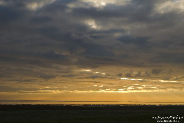 Sonnenaufgang über dem Watt, Wolken, Lichtstrahlen, am Horizont Kette von Halligen: Langeneß, Hooge, Amrum, Deutschland