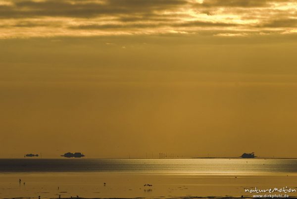 Sonnenaufgang über dem Watt, Wolken, Lichtstrahlen, am Horizont Kette von Halligen: Langeneß, Hooge, Amrum, Deutschland