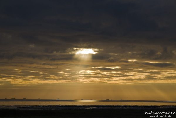 Sonnenaufgang über dem Watt, Wolken, Lichtstrahlen, am Horizont Kette von Halligen: Langeneß, Hooge, Amrum, Deutschland