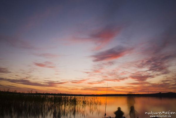 Sonnenuntergang am Käbelicksee, Wolkenformationen, Schilfsaum, Angler auf dem Steg, verwischt da lange Belichtungszeit, Kratzeburg, Deutschland