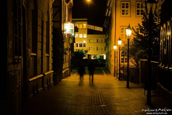 Fußgänger in der Gasse vor dem Irish Pub, Nachbeleuchtung, Göttingen, Deutschland