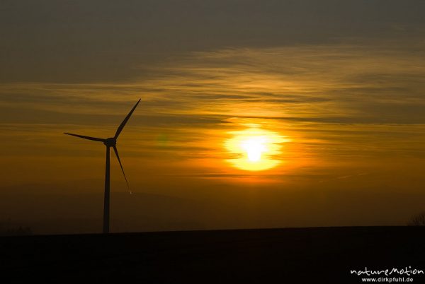 Windrad und untergehende Sonne, Sonnenscheibe inmitten orangerotem Himmel, Göttingen, Deutschland