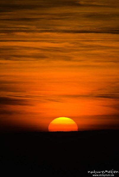 Sonne versinkt als rote Scheibe hinter dem Horizont, roter Himmel, Göttingen, Deutschland