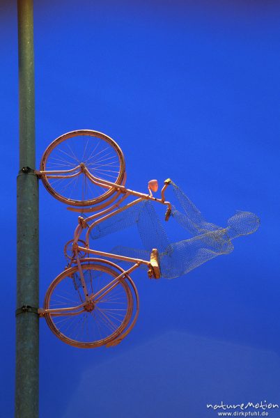 Fahrrad mit Fahrer aus Draht, senkrecht an Lichtmast, Campus der Universität, bei Nacht, Göttingen, Deutschland