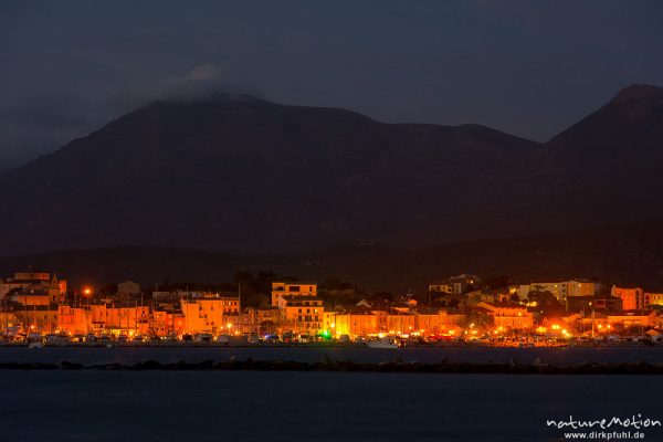 Saint Florent am Abend, Blick über die Bucht auf die erleuchtete Stadt und den Hafen, Korsika, Frankreich