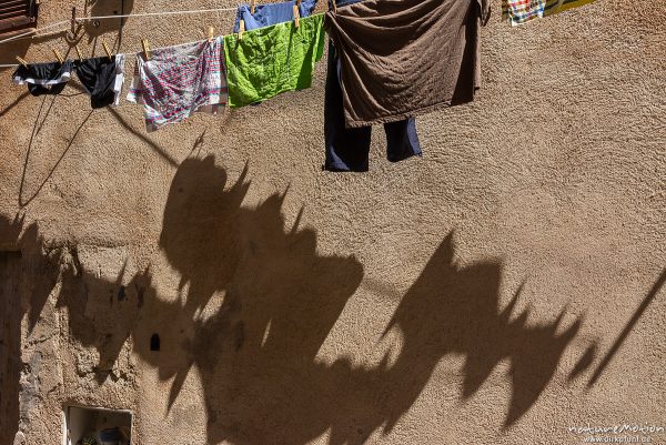 Wäsche auf Wäscheleine, Schatten auf Hausfassade, schmale Gassen und Fassaden in der Altstadt von Bonifacio, Korsika, Frankreich