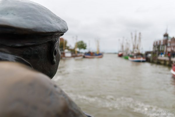 Bronzestatue eines Fischers schaut in den Hafen, Neuharlingersiel, Deutschland