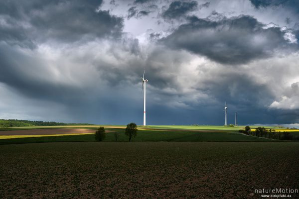 Windräder inmitten von Ackerflächen, Regenwolken, Landolfshausen im Eichsfeld, Deutschland