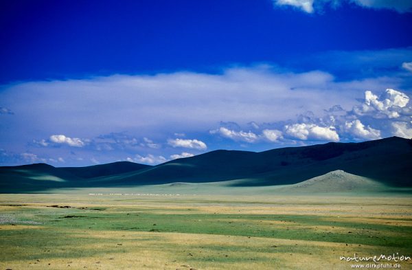Höhenzug mit Wolkenschatten, davor ein Ail aus vielen weißen Jurten, Changai, Mongolei