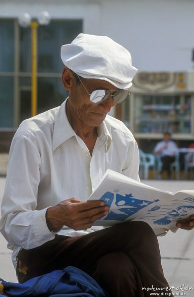 lesender Strassenverkäufer, Buchhändler, mit weißer Schirmmütze und verspiegelter Sonnenbrille, Ulaanbaatar - Ulan Bator, Mongolei