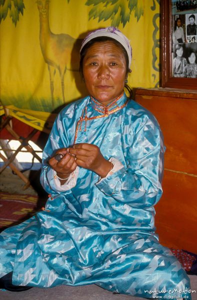 Frau in türkisfarbenem Deel beim Nähen eines Deels, Mongol Els, Mongolei