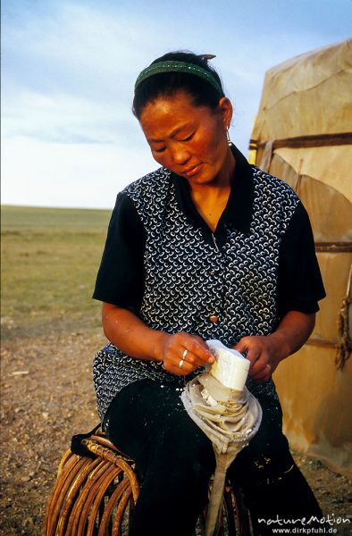 Frau schneidet mit dem Haar eines Pferdeschweifs Aaruul-Stücke ab und legt sie zum trocknen aus, Wüste Gobi, Mongolei