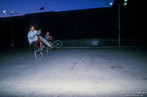 Fahrradkunststücke, Jugendliche vor Parlamentsgebäude, Suchbataar-Platz, im Dunkeln, ,