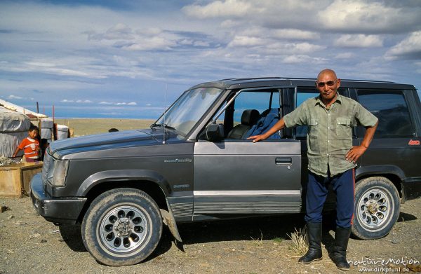 Mann, Oberhaupt der Familie vor seinem neuen Geländewagen, Mongol Els, Mongolei