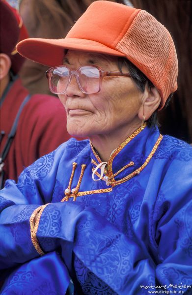 alte Frau in blauem Deel und orangener Baseball-Mütze, Zuschauerin beim Ringkampf, , Mongolei