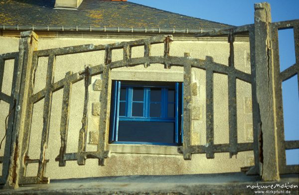 Haus mit zerfallenem Zaun aus Beton, Fenster mit blauen Fensterläden, Bretagne, Frankreich
