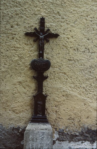 gusseisernes Grabkreuz an Hausmauer, Grabspruch: "Hier liegen meine Gebeine, ich wollt es wären deine", Passau, Passau, Deutschland